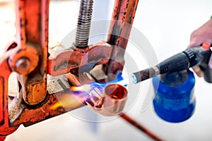 worker using propane gas torch for soldering copper pipes.