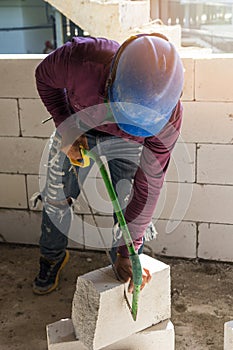 Worker using saw for cutting foam bricks