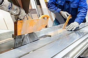 Worker using saw machine to make furniture at carpenters workshop. photo