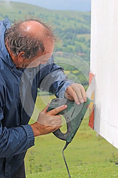 Worker using a saw to cut fibreglass photo