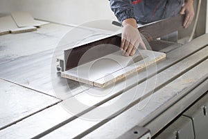 Worker using silicone glueCloseup process of carpenter worker with circular saw machine at wood beam cross cutting during