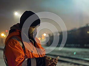 Worker using smartphone in the twilight. Concept of night shift