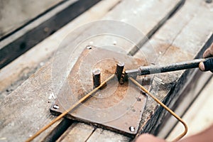 Worker using steel wire and pincers to bend steel bars, preparing for concrete pouring on construction site