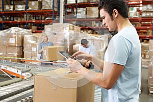 Worker Using Tablet Computer In Distribution Warehouse