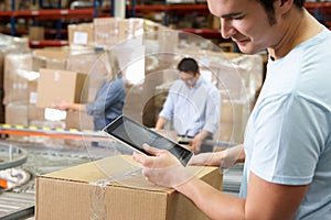 Worker Using Tablet Computer In Distribution Warehouse