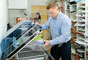 Worker using vacuum packing machine in printing shop