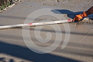 Worker using a wooden spatula for cement after Pouring ready-mixed concrete