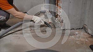 Worker vacuuming concrete floors. Preparing the floor for waterproofing. construction cleaning with an industrial vacuum cleaner.