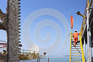 Worker walking up stairs at jack up oil and gas rig