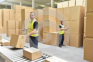 Worker in a warehouse in the logistics sector processing packages on the assembly line - transport and processing of orders in