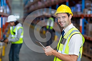 Worker in warehouse looking at camera