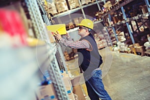 Worker In Warehouse Preparing Goods For Dispatch