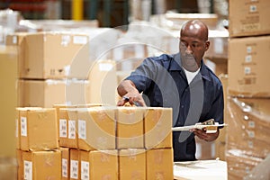 Worker In Warehouse Preparing Goods For Dispatch