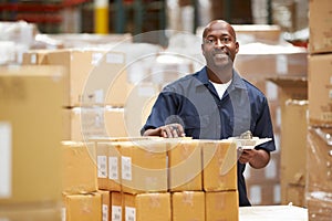 Worker In Warehouse Preparing Goods For Dispatch