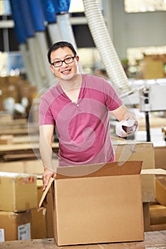 Worker In Warehouse Preparing Goods For Dispatch