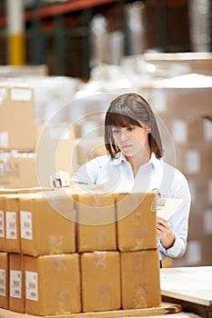 Worker In Warehouse Preparing Goods For Dispatch