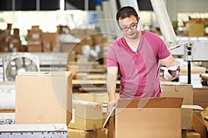 Worker In Warehouse Preparing Goods For Dispatch