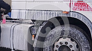 A worker washes a big truck