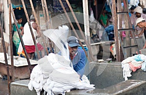 Worker washing clothes at Dhobi Ghat in Mumbai, India