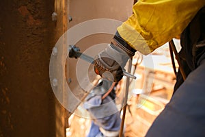 Worker wearing a glove using socket tensioning nut attached into the structure metal wall