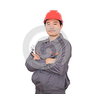 Worker wearing a red hard hat holding a wrench in hand standing in front of white background with his arms