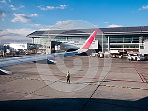 worker wearing safety equipment guiding a plane during taxiing for take off