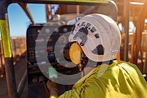 worker wearing safety noise disruptive earmuffs protection while inspecting working near generator