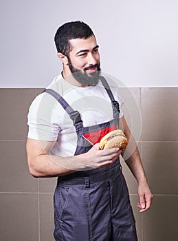 Worker wearing uniform eating burger during lunch break