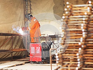 Worker weld metal gratings by acetylene torch photo
