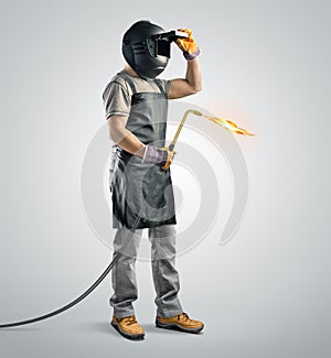 Worker welder in a protective mask with gas welding machine