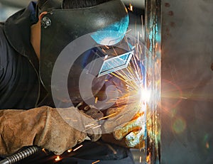 Worker welding construction by MIG welding