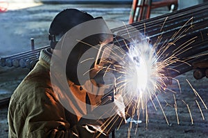 Worker welding with electric arc electrode