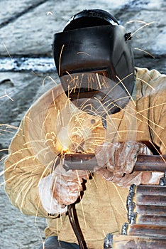 Worker welding with electric arc electrode photo