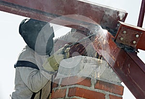 Worker welding with electric arc electrode photo