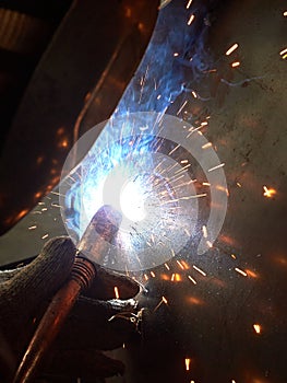 worker welding equipment parts in the workshop