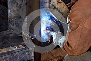 worker welding equipment parts in the workshop