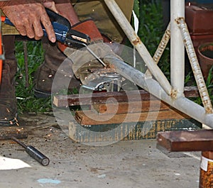 Worker with a welding machine fixing a caster wheels, fiery sparks flying around