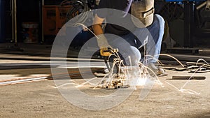 worker welding metal, focus on flash light line of sharp spark,in low light