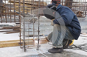 Worker welding a metal lattice at