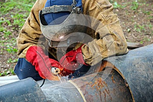 Worker Welding Metal Piping