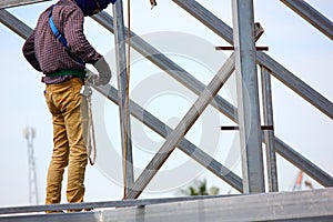 The worker welding metal on roof structure