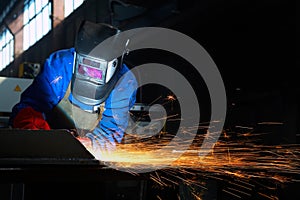 Worker welding metal and sparks