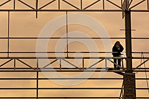 Worker welding metal at sunset