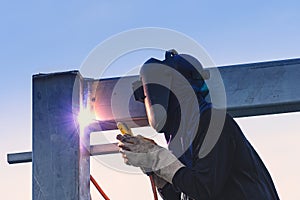 Worker welding parts of stell construction