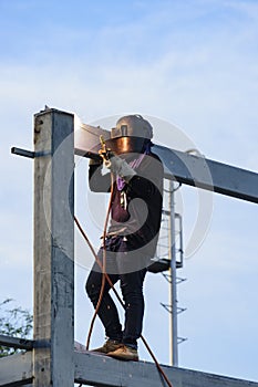 Worker welding parts of stell construction