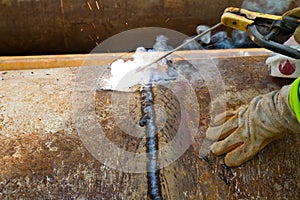 Worker welding the pipe