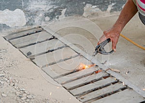 Worker welding stainless steel gril of drian rail