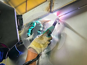 Worker welding stainless tank using tig welder