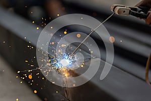 Worker welding steel pipe in construction site