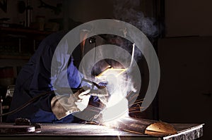 Worker welding in workshop.